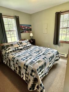 Un dormitorio con una cama con una manta a cuadros. en 27 Acre Wine Country Estate, en Austinburg