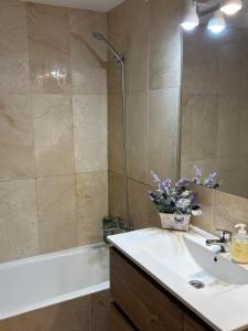 Un baño con lavabo, bañera y espejo. en Charming 3 Bedroom apartment with sea view in the heart of Sotogrande, en Sotogrande 8 fotos más