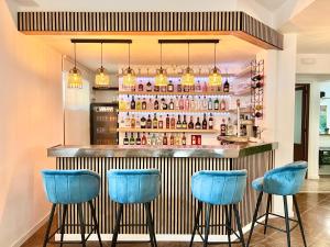 eine Bar mit blauen Barhockern in einem Raum in der Unterkunft Hotel LM in Lloret de Mar