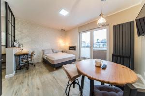 a bedroom with a bed and a table and a table sidx sidx sidx at Apartamenty Pod Żaglami in Dziwnówek