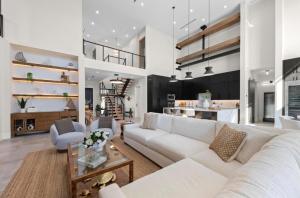 a living room with a white couch and a kitchen at Coastal Luxe, SaltPool Spa, 5miles to Siesta in Sarasota