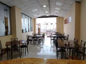 a dining room with tables and chairs and a large window at Hotel 4 Rios in Cuenca