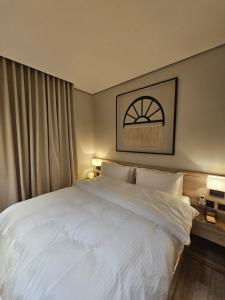 ein Schlafzimmer mit einem großen Bett mit weißer Bettwäsche in der Unterkunft سدارا للأجنحه الفندقيه in Riad