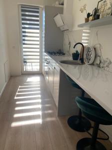 a kitchen with a counter and a sink and chairs at Smart Residence in Baia Mare