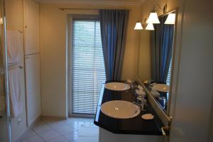 un bagno con due lavandini e un grande specchio di Herrenhaus Gästewohnung a Poseritz Altre 3 foto