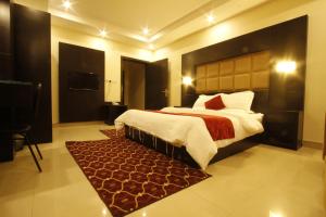 a bedroom with a large bed and a red rug at Manazel Al Hamra Apartment 2 in Buraydah