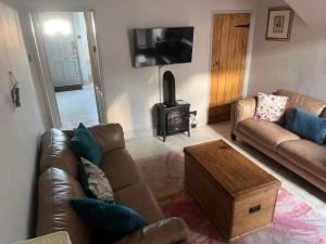 - un salon avec un canapé et un poêle à bois dans l'établissement Riverside Cottage, à Tewkesbury
