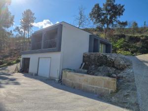 a white house with a balcony on top of a stone wall at Felicidade in Mondim de Basto