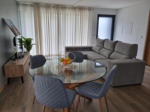 a living room with a couch and a glass table at Felicidade in Mondim de Basto