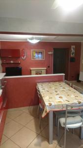 a table and chairs in a kitchen with red walls at La Casetta di Mimma in Viggiano