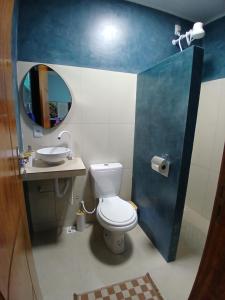 a bathroom with a toilet and a sink and a mirror at Casa Moriá in Lençóis +12 photos