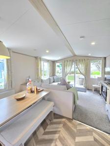 ein Wohnzimmer mit Sofa und Tisch in der Unterkunft Cornwall Caravan Retreat, Near Perranporth, 3 Bedroom in Newquay