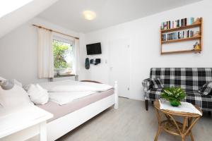 a white bedroom with a bed and a couch at Haus Delphin in Juist