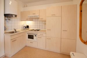 Una cocina con gabinetes blancos y un fregadero. en Bungalow Nebel Nr 2, en Kellenhusen