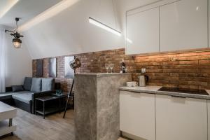 una cocina con armarios blancos y una pared de ladrillo en Rynek 2A - Old Town, en Wroclaw
