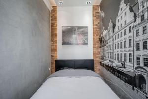 Un dormitorio con una cama en una pared de ladrillos. en Rynek 2A - Old Town, en Wroclaw