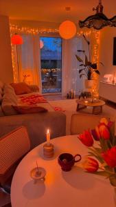 una sala de estar con una mesa con una vela y flores en Harmony House, en Sheikh Zayed