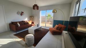 a living room with a couch and a table at La Pétillante in Vaux-sur-Mer