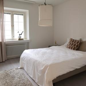 a bedroom with a large white bed with a window at Henniina V Pakkahuone I - Sauna & Free Parking in Oulu