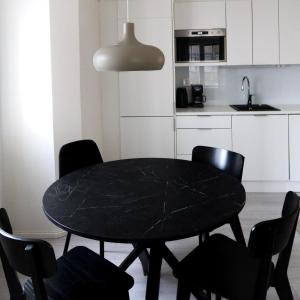 a black table and chairs in a kitchen at Henniina V Pakkahuone I - Sauna & Free Parking in Oulu
