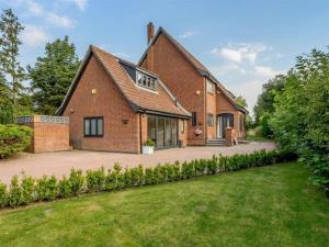 a brick house with a lawn in front of it at Ferienwohnung in Westerland auf Sylt in Westerland (Sylt)