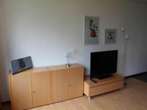 a television sitting on top of a wooden entertainment center at Ferienwohnung in Westerland auf Sylt in Westerland (Sylt)