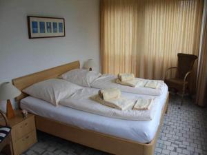 a bedroom with a bed with towels on it at Ferienwohnung in Westerland auf Sylt in Westerland (Sylt) +14 photos