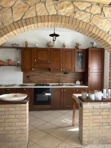 a kitchen with wooden cabinets and a stone wall at Green Residence Villa Assunta in Moscufo
