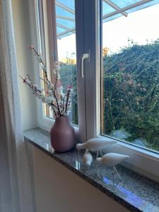 a vase with flowers sitting on a window sill at Villa Maris Izola in Izola