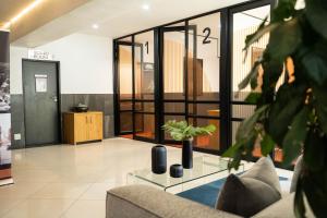 a living room with a couch and a glass table at Two At Urban Pulse in Johannesburg