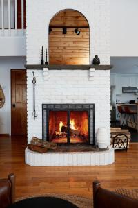 a living room with a white brick fireplace at Cozy Lux Mountain Lodge Hot Tub Mtn Views Skiing in Jewett