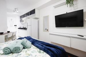 a white room with a bed and a flat screen tv at SanLoft Expo Inn Tietê 05 - Preferido! in Sao Paulo