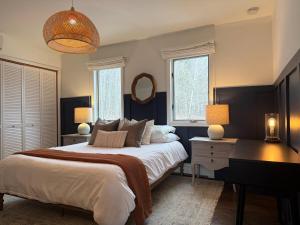 a bedroom with a bed and a desk and a mirror at Cozy Lux Mountain Lodge Hot Tub Mtn Views Skiing in Jewett