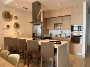 a kitchen with a kitchen island with chairs and a counter top at Luxury Velamar Penthouse in Miramar