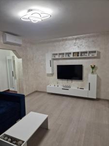 クラヨーヴァにあるBN Titulescu Apartamentの壁に薄型テレビが取り付けられたリビングルーム