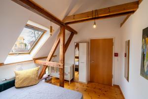 施维洛塞Romantisches Retro Loft Caputh bei Potsdam - neu!的阁楼卧室设有床和窗户。
