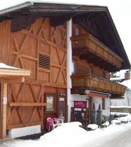 un edificio in legno con balcone e sedie rosa di Haus Sonja a Lermoos