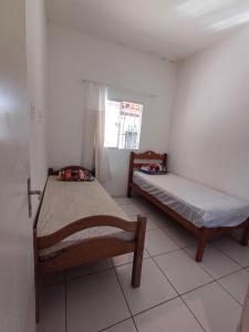 deux lits dans une petite pièce avec une fenêtre dans l'établissement Mansão próximo a lagoa, à São José de Mipibu