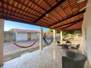 d'une terrasse avec un hamac, une table et des chaises. dans l'établissement Mansão próximo a lagoa, à São José de Mipibu