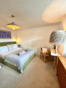 una camera da letto con un letto e una sedia di Palms 1 - Wood burner, 5 min walk to beach+parking a Newquay