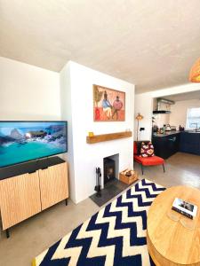 un soggiorno con TV a schermo piatto e tavolo di Palms 1 - Wood burner, 5 min walk to beach+parking a Newquay