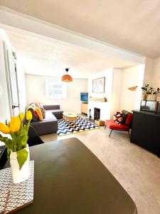 un soggiorno con un divano e un tavolo di Palms 1 - Wood burner, 5 min walk to beach+parking a Newquay Altre 10 foto