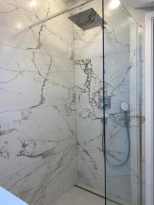 a bathroom with a shower with a marble wall at Alea in Tuttlingen +11 photos
