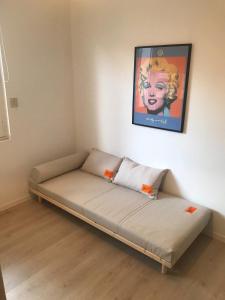 ラ・ボールにあるMaison à 10mn à pieds de la plageの壁に絵が掛かっている部屋のベッド