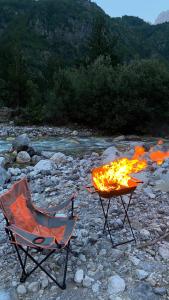 two chairs sitting next to a camp fire on a river at ALB Car Camping in Grilë +10 photos