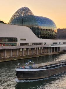 una barca in acqua davanti a un edificio di Appartement spacieux, jacuzzi, lumineux, calme, T2, 56m2 a Boulogne-Billancourt
