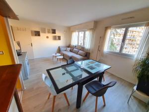 un soggiorno con tavolo e sedie in vetro di Appartement spacieux, jacuzzi, lumineux, calme, T2, 56m2 a Boulogne-Billancourt