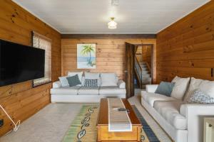 a living room with two couches and a flat screen tv at Kawaha on the Lake in Rotorua