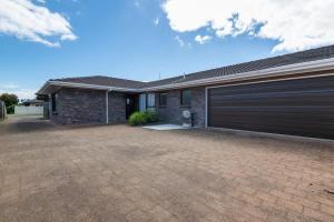une maison avec deux portes de garage dans une allée dans l'établissement Central Hotspot, à Rotorua