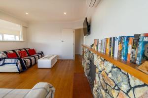 a living room with a book shelf and a couch at All Seasons Escape in Rotorua